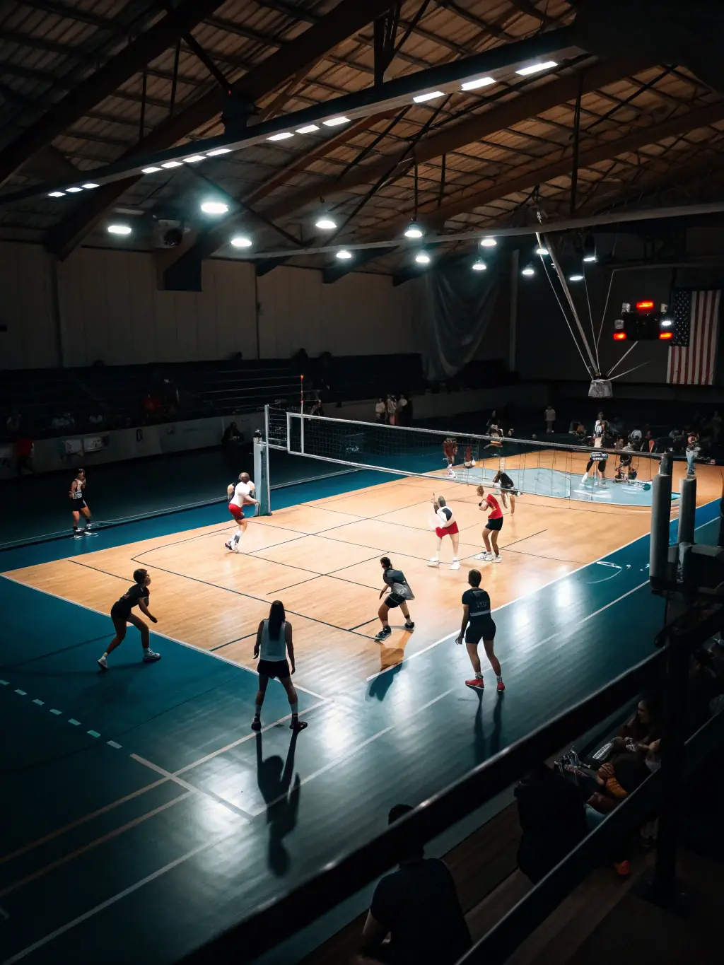 An action shot of a volleyball game in progress, highlighting the teamwork and competitive spirit of the COMITE DEPARTEMENTAL E P M M's volleyball program. Players are diving and spiking the ball.